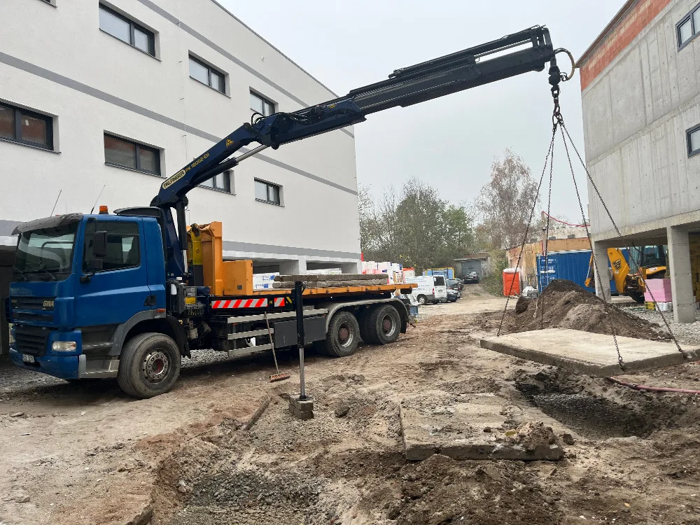 Nosič kontejnerů s hydraulickou rukou při nakládce