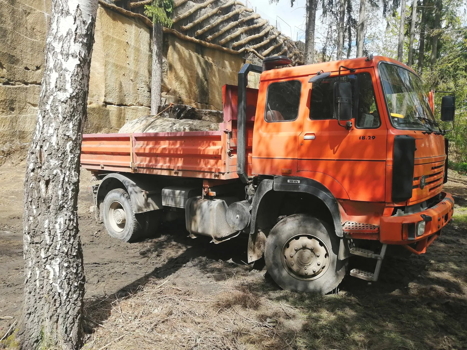 Traktorbagr při nakládání vytěžené zeminy